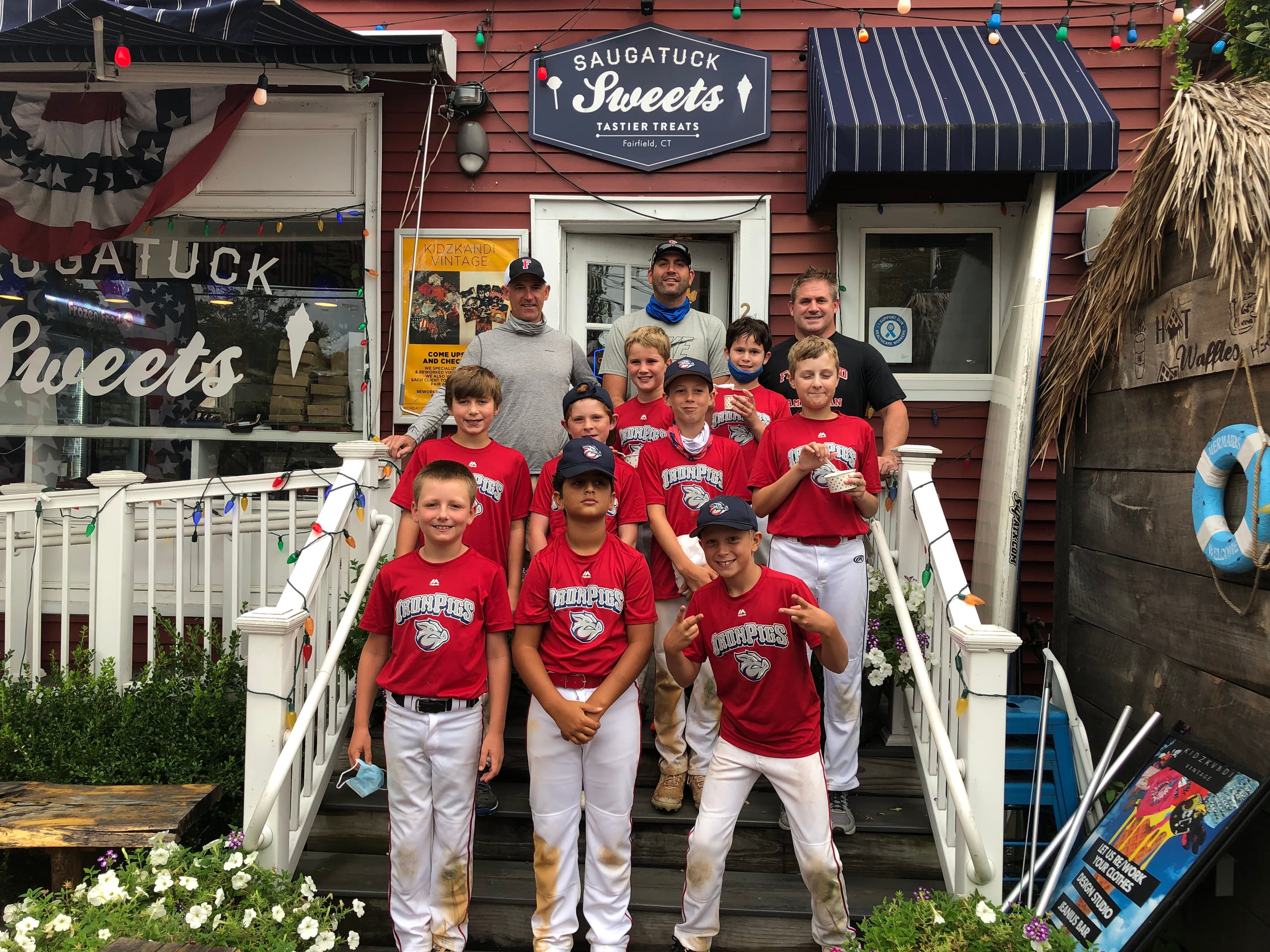 The Iron Pigs little league team on the shop steps with ice cream
